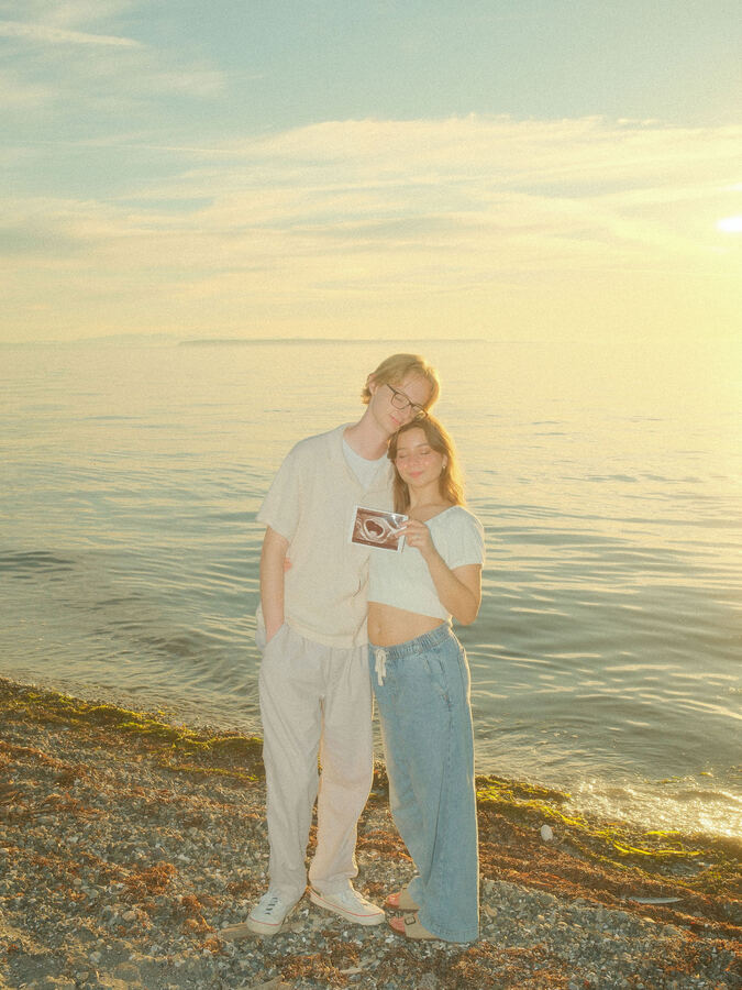 Bride and groom wading into the water with Just Married sign