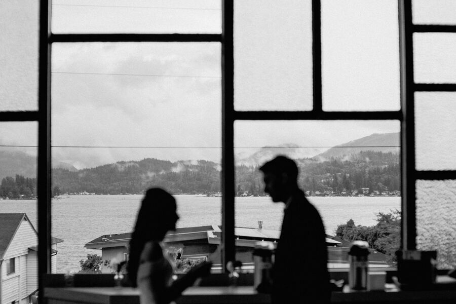 Silhouetted couple framed by tall windows